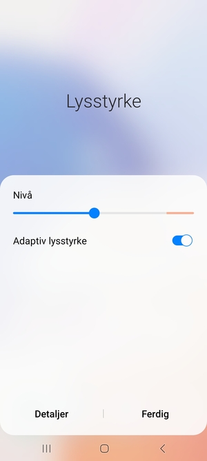 Slå på Adaptiv lysstyrke og velg Utført