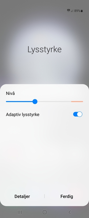 Slå på Adaptiv lysstyrke og velg Utført